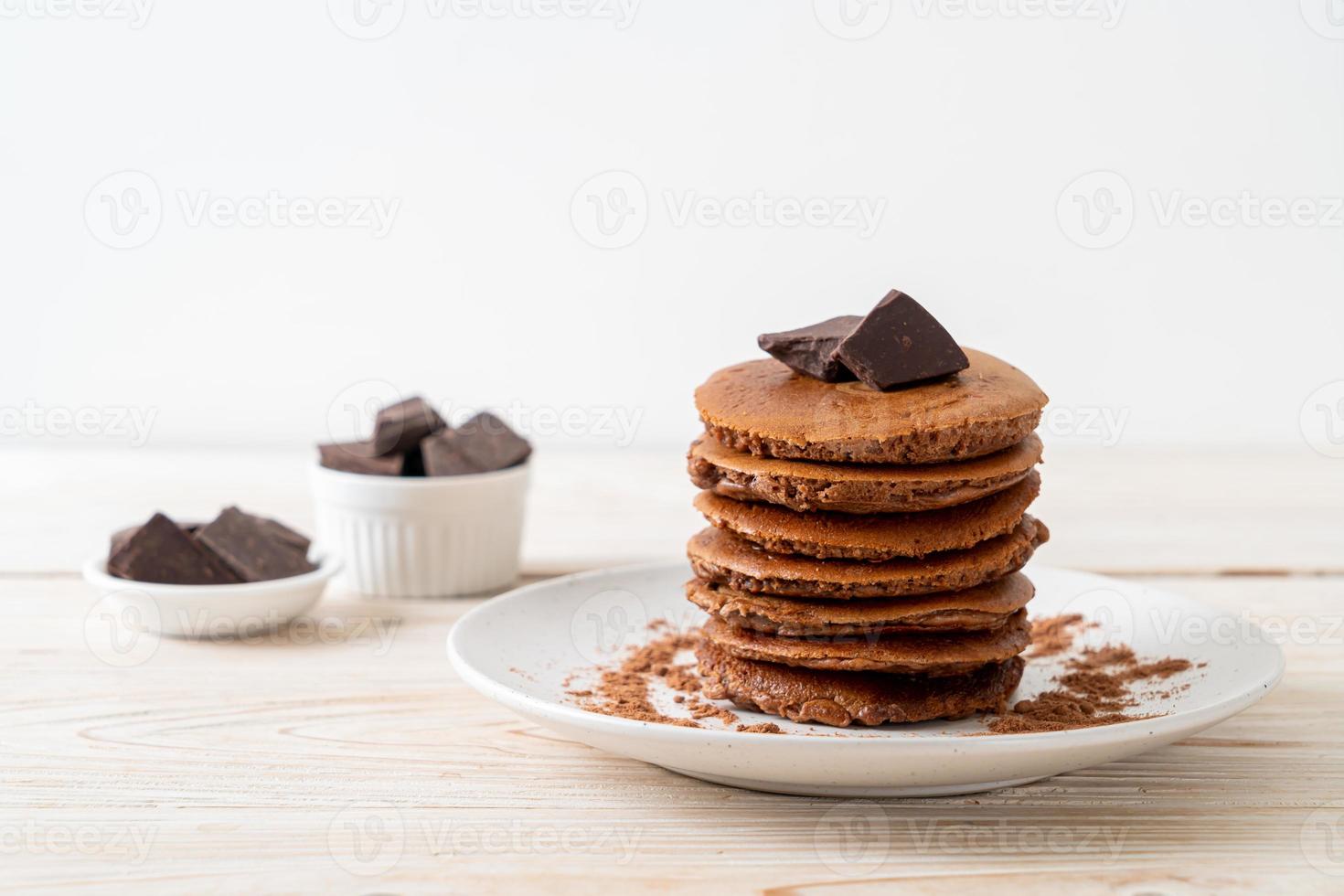 pila di pancake al cioccolato con cioccolato in polvere foto