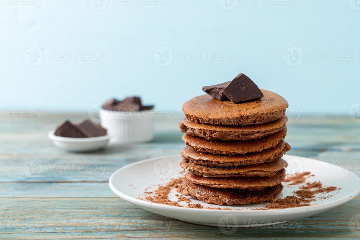 pila di pancake al cioccolato con cioccolato in polvere foto