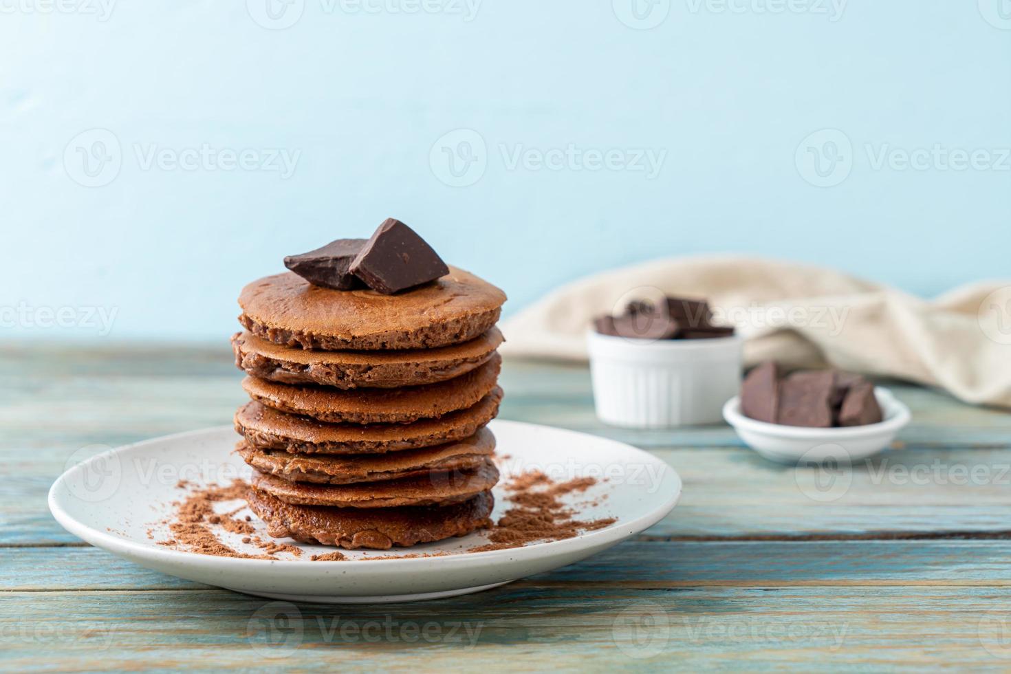 pila di pancake al cioccolato con cioccolato in polvere foto