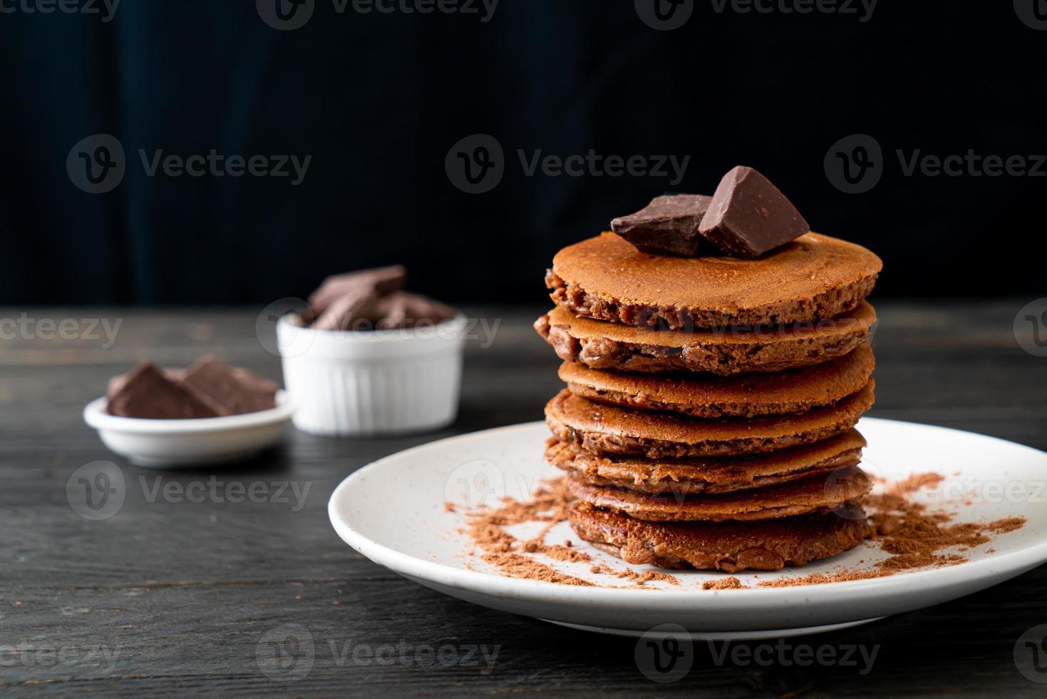 pila di pancake al cioccolato con cioccolato in polvere foto