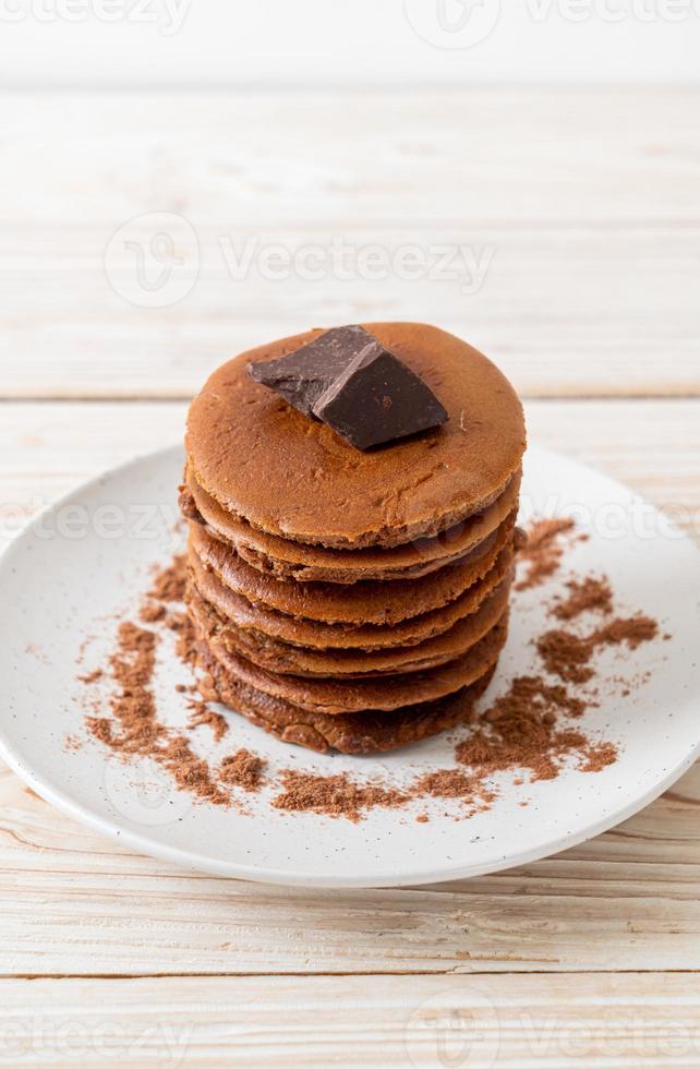 pila di pancake al cioccolato con cioccolato in polvere foto