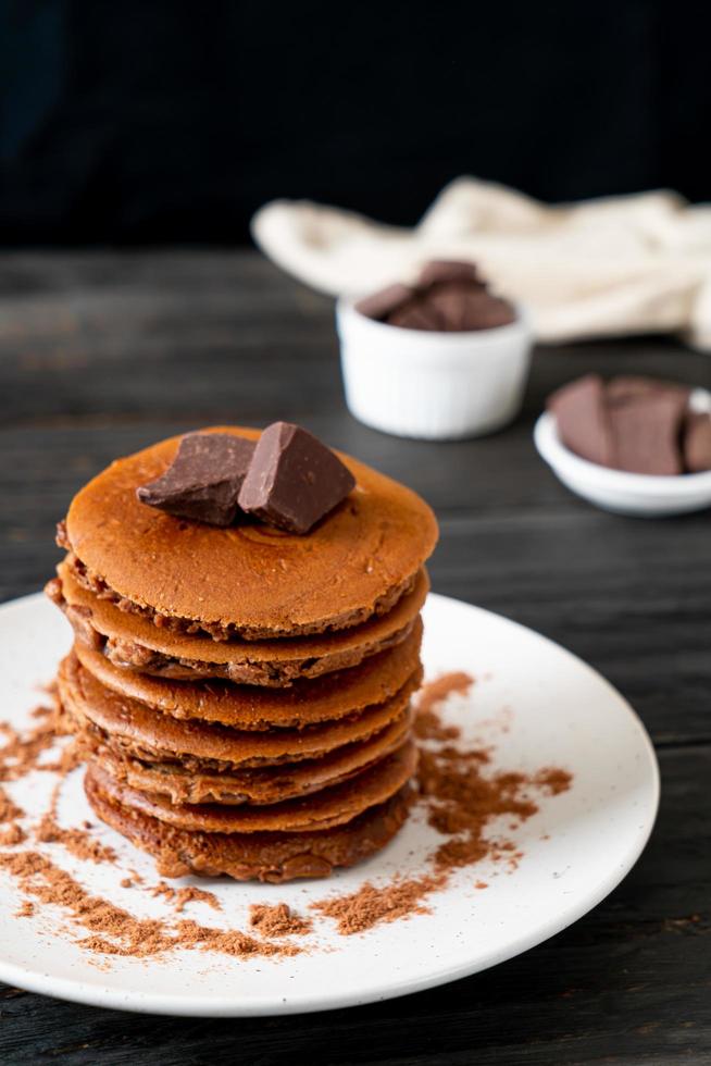 pila di pancake al cioccolato con cioccolato in polvere foto