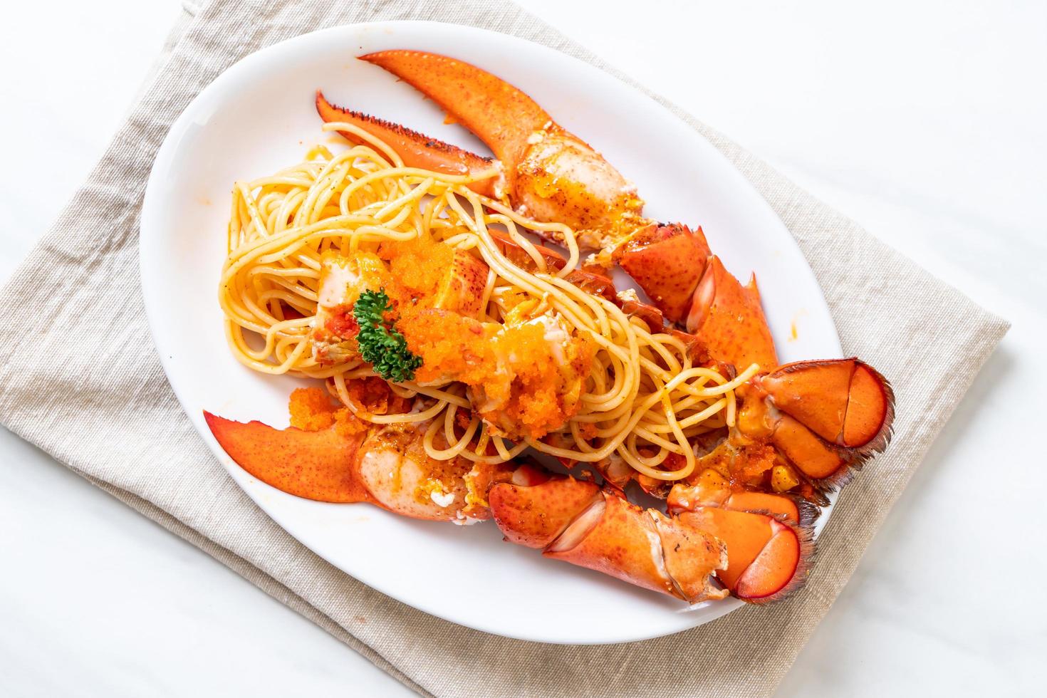 spaghetti all'aragosta con uovo di gamberi su piatto bianco foto