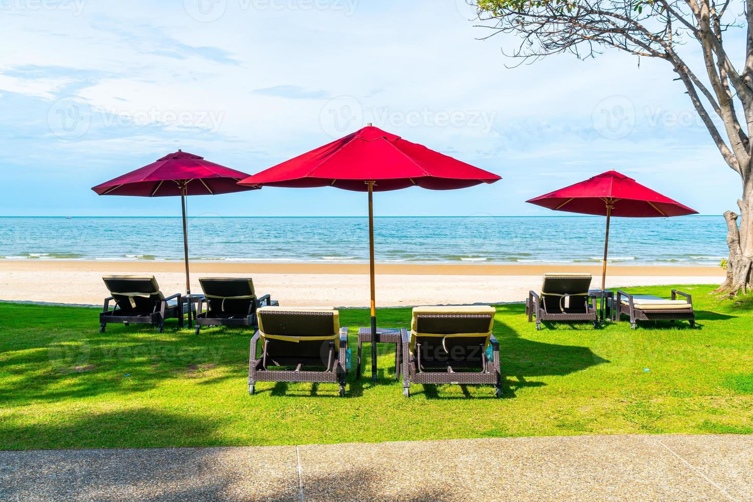 sedie a sdraio e ombrelloni con sfondo spiaggia mare oceano foto