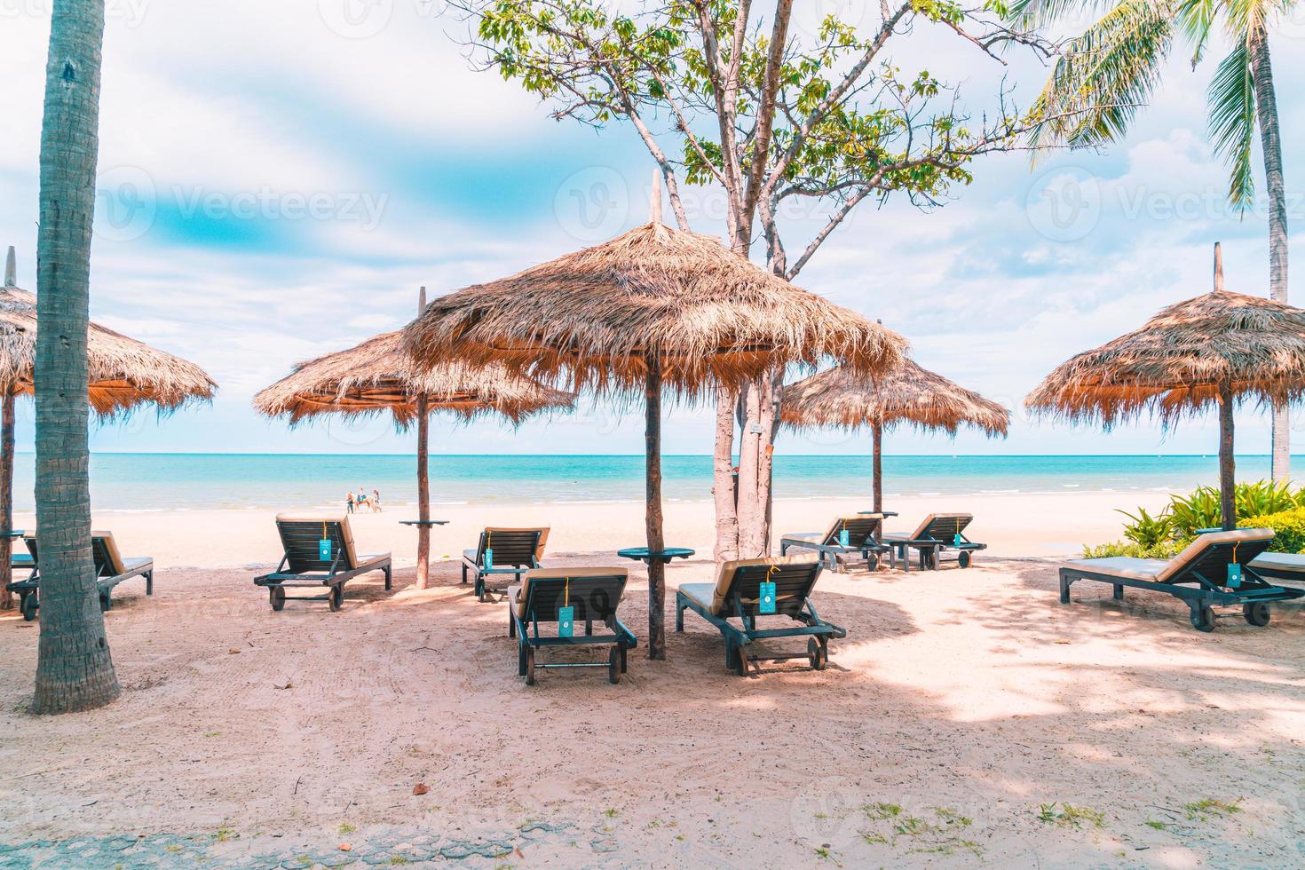 sedie a sdraio e ombrelloni con sfondo spiaggia mare oceano foto