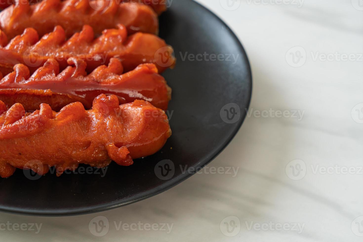 spiedino di salsiccia fritta su piastra nera foto