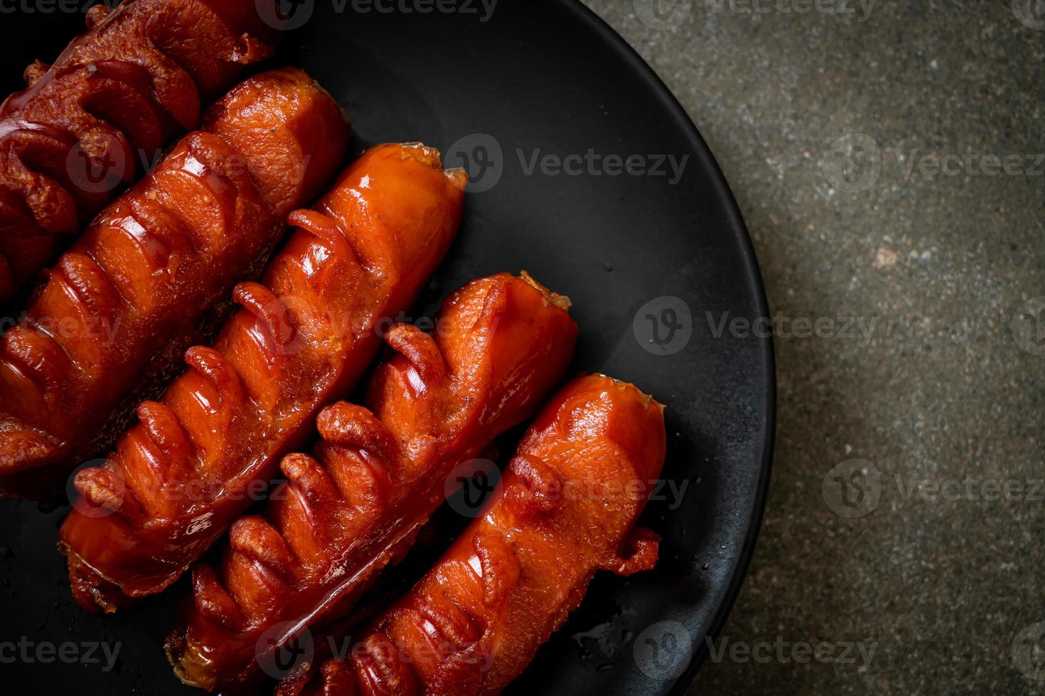 spiedino di salsiccia fritta su piastra nera foto