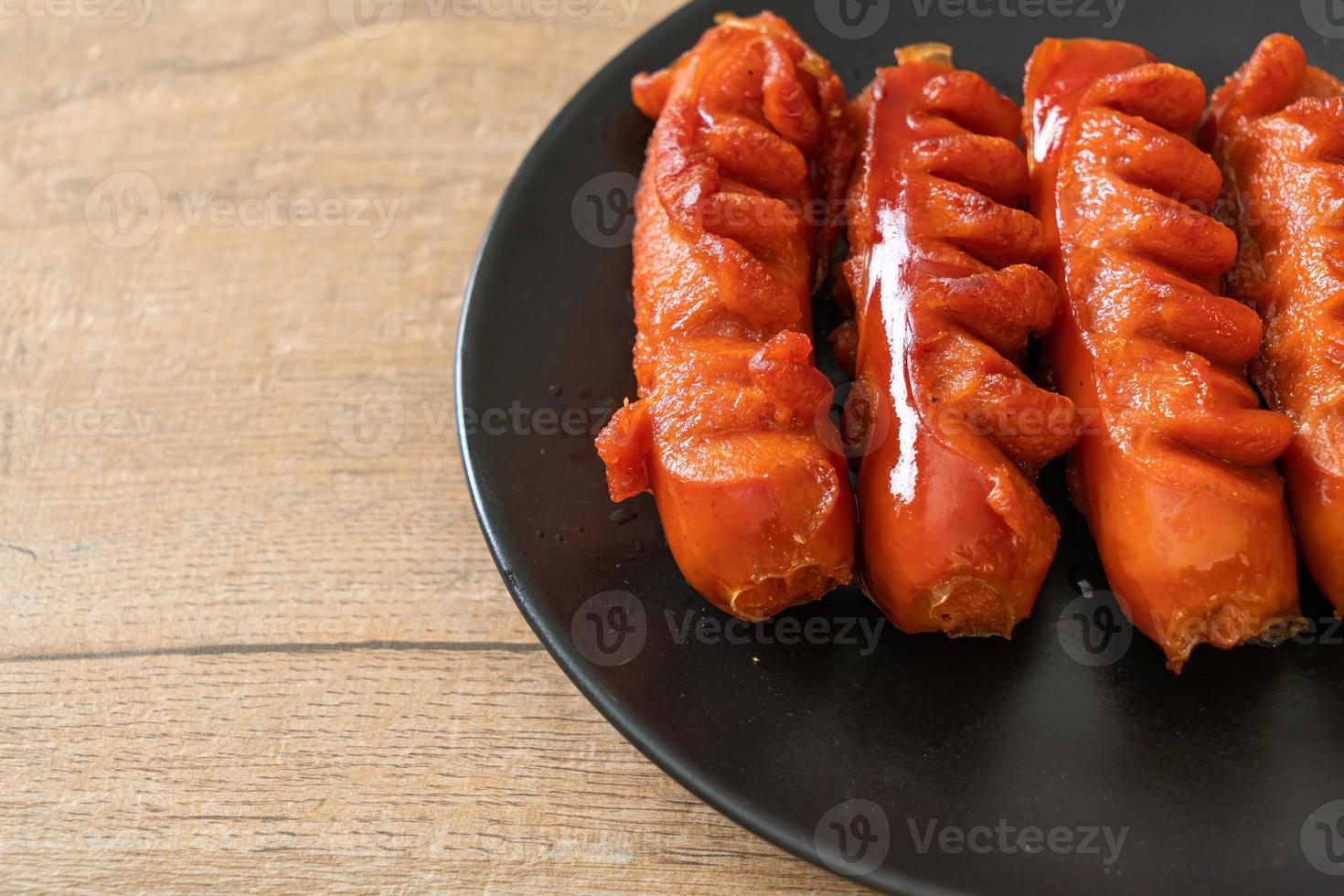 spiedino di salsiccia fritta su piastra nera foto