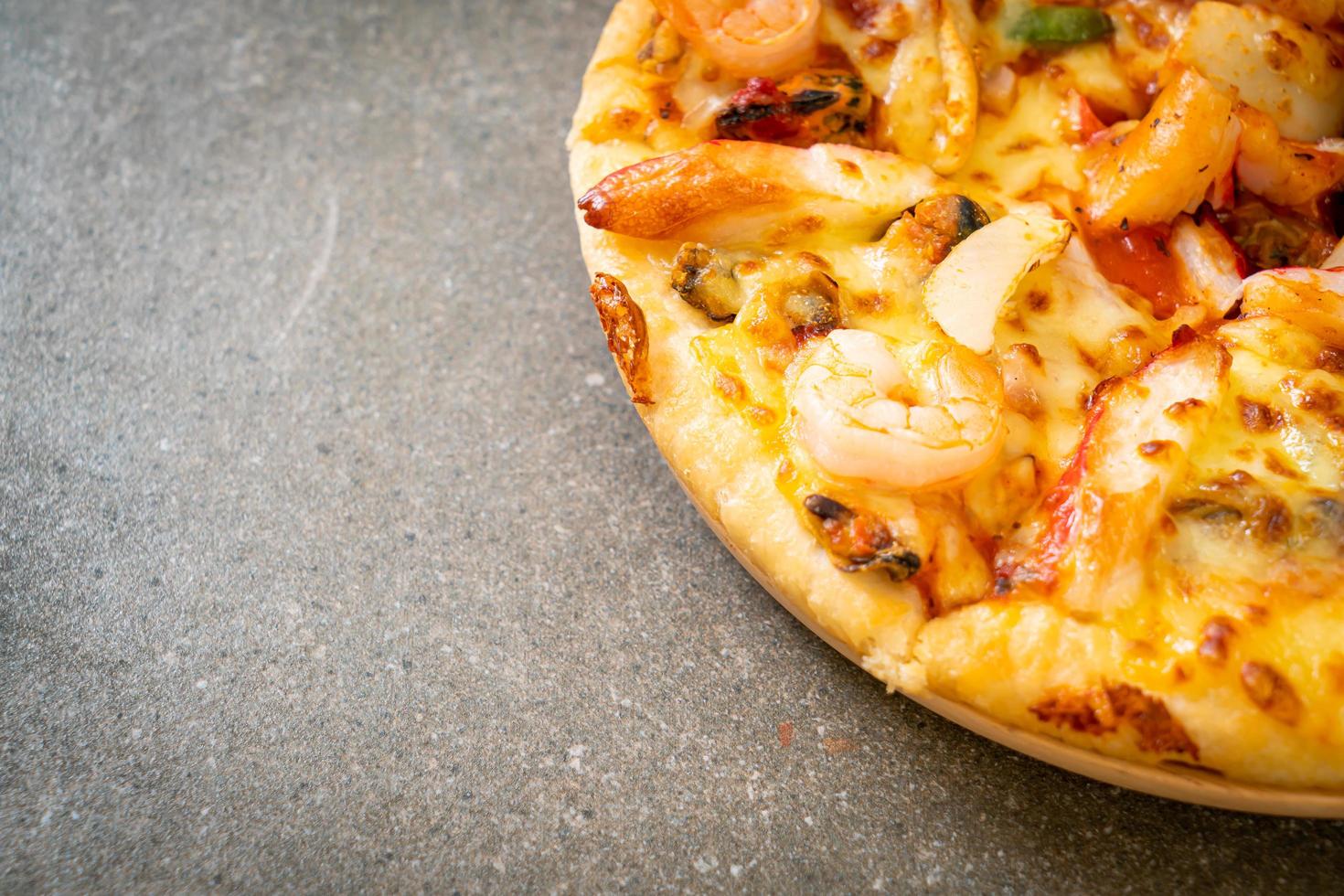 pizza con gamberi, polpo, cozze e granchio su vassoio di legno foto