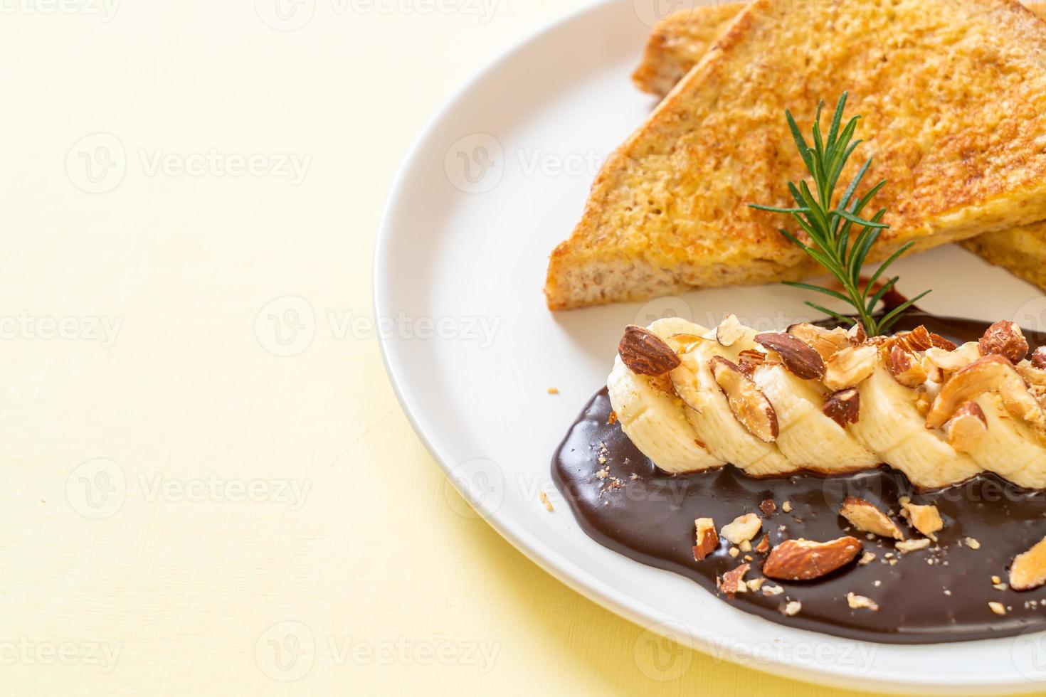 French toast con banana, cioccolato e mandorle a colazione foto