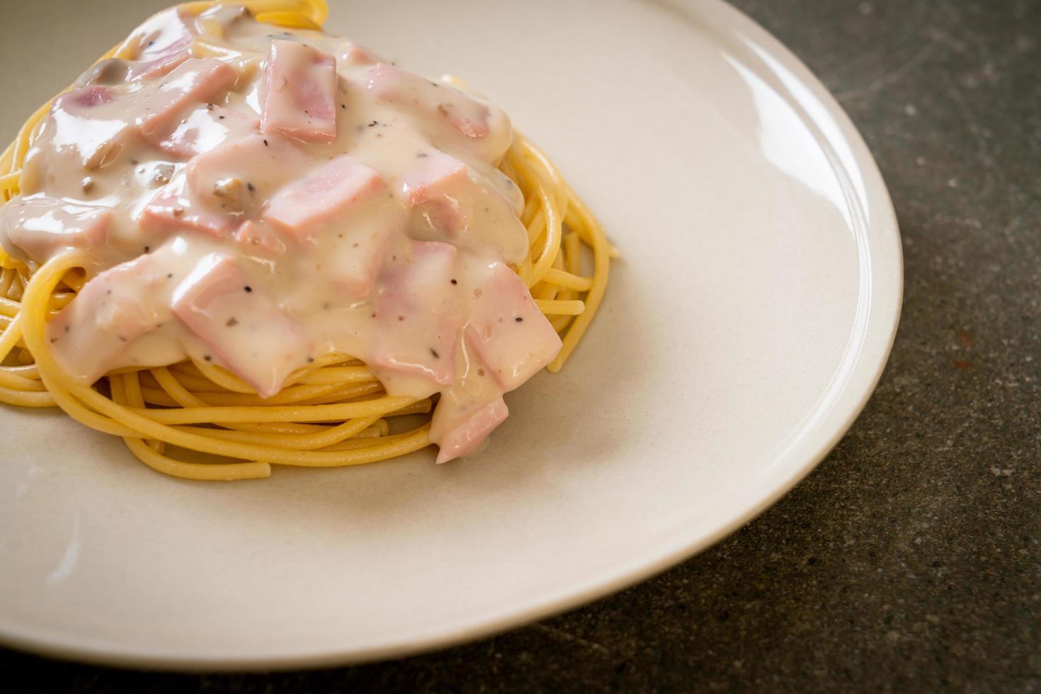 spaghetti fatti in casa salsa di panna bianca con prosciutto - stile italiano foto