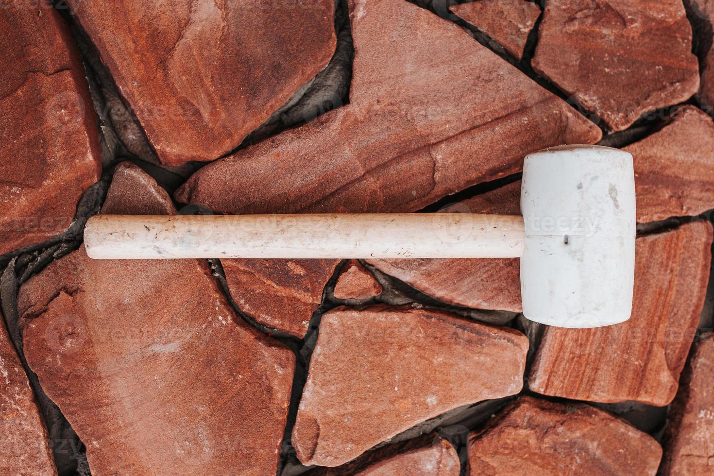 posa di piastrelle ricce su colla - imitazione della pietra naturale - di fronte alla casa dall'esterno foto