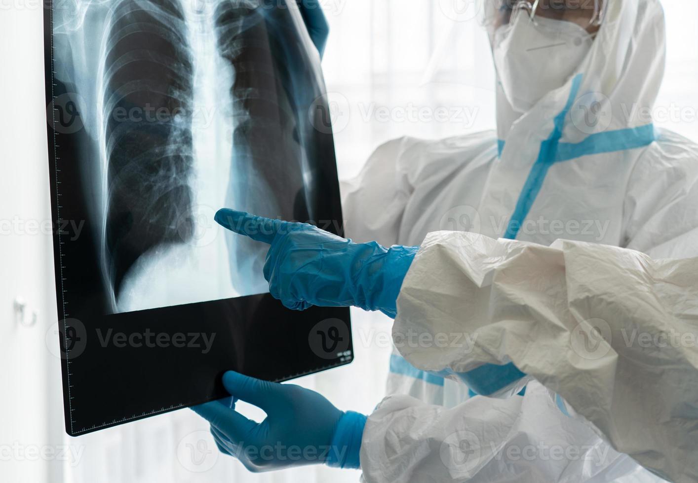 medici in dispositivi di protezione individuale o dpi che esaminano la radiografia del torace della paziente asiatica con covid-19 o infezione da coronavirus nell'unità di isolamento dell'ospedale. concetto medico foto