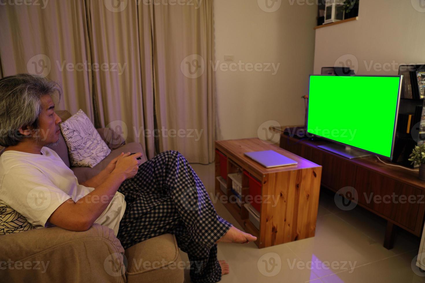 uomo asiatico che guarda la televisione foto