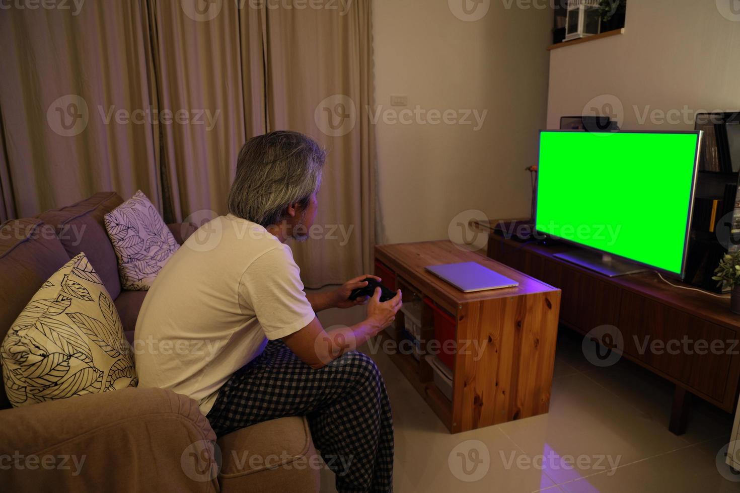 uomo asiatico che guarda la televisione foto