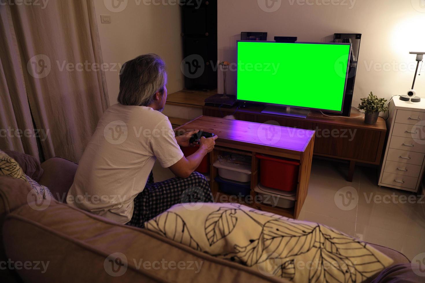 uomo asiatico che guarda la televisione foto