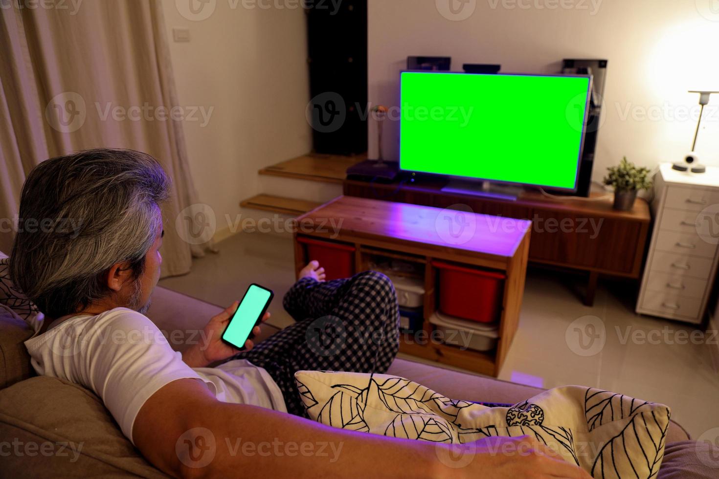 uomo asiatico che guarda la televisione foto