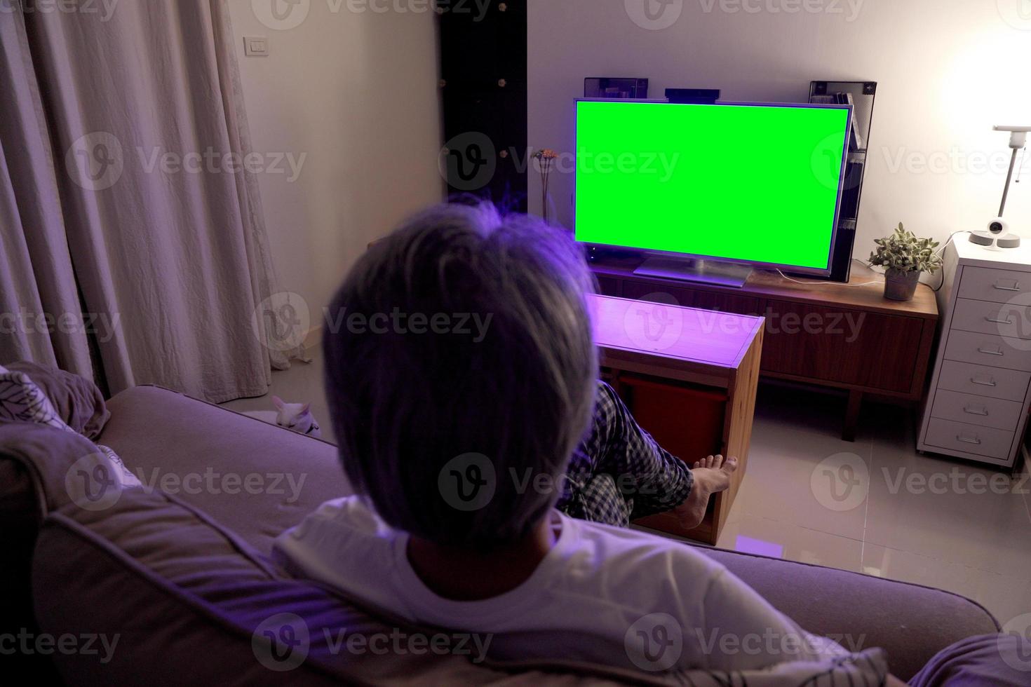 uomo asiatico che guarda la televisione foto