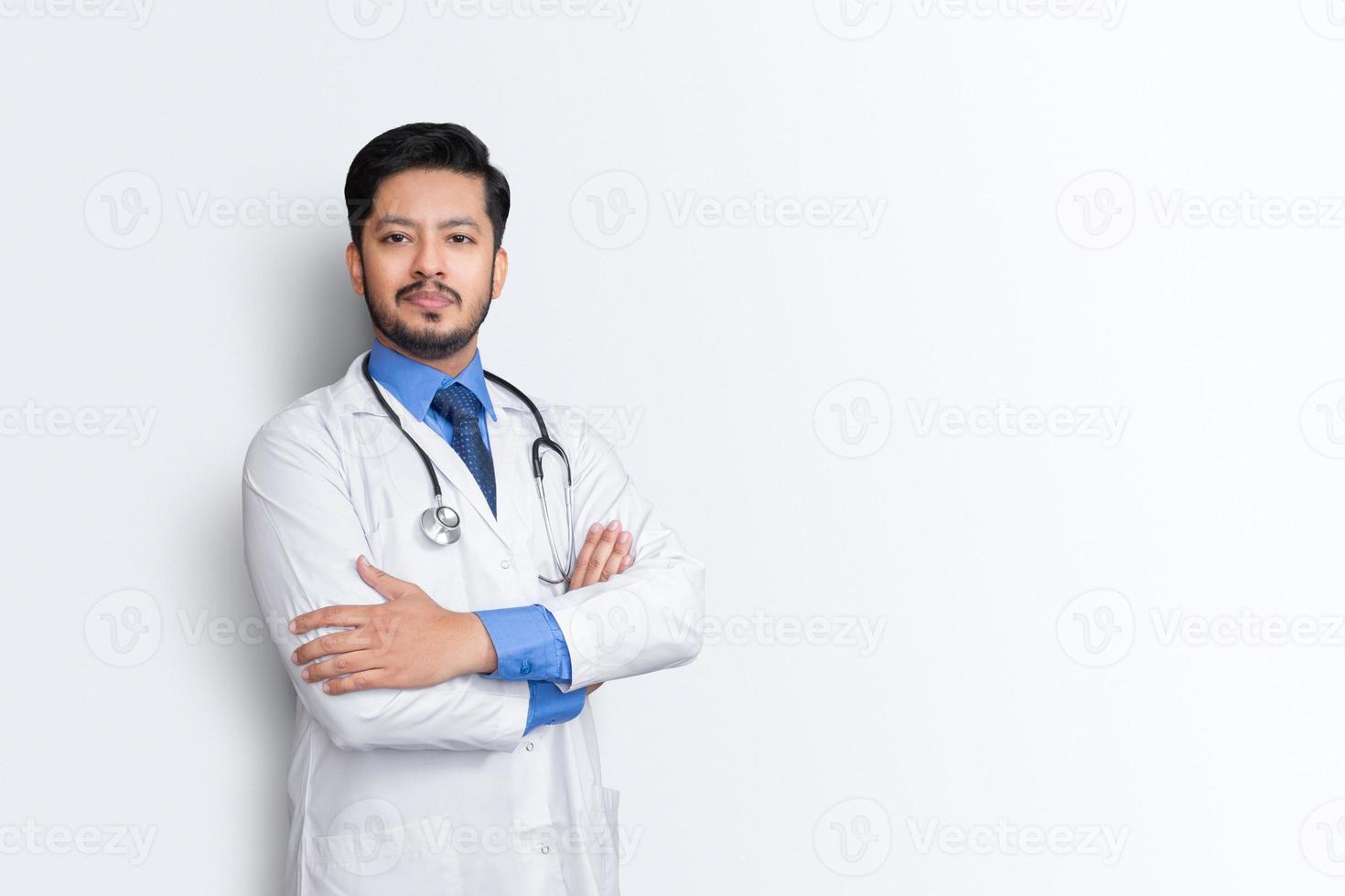 ritratto di medico maschio con stetoscopio e croce braccio isolato su sfondo bianco. concetto di assicurazione sanitaria. foto