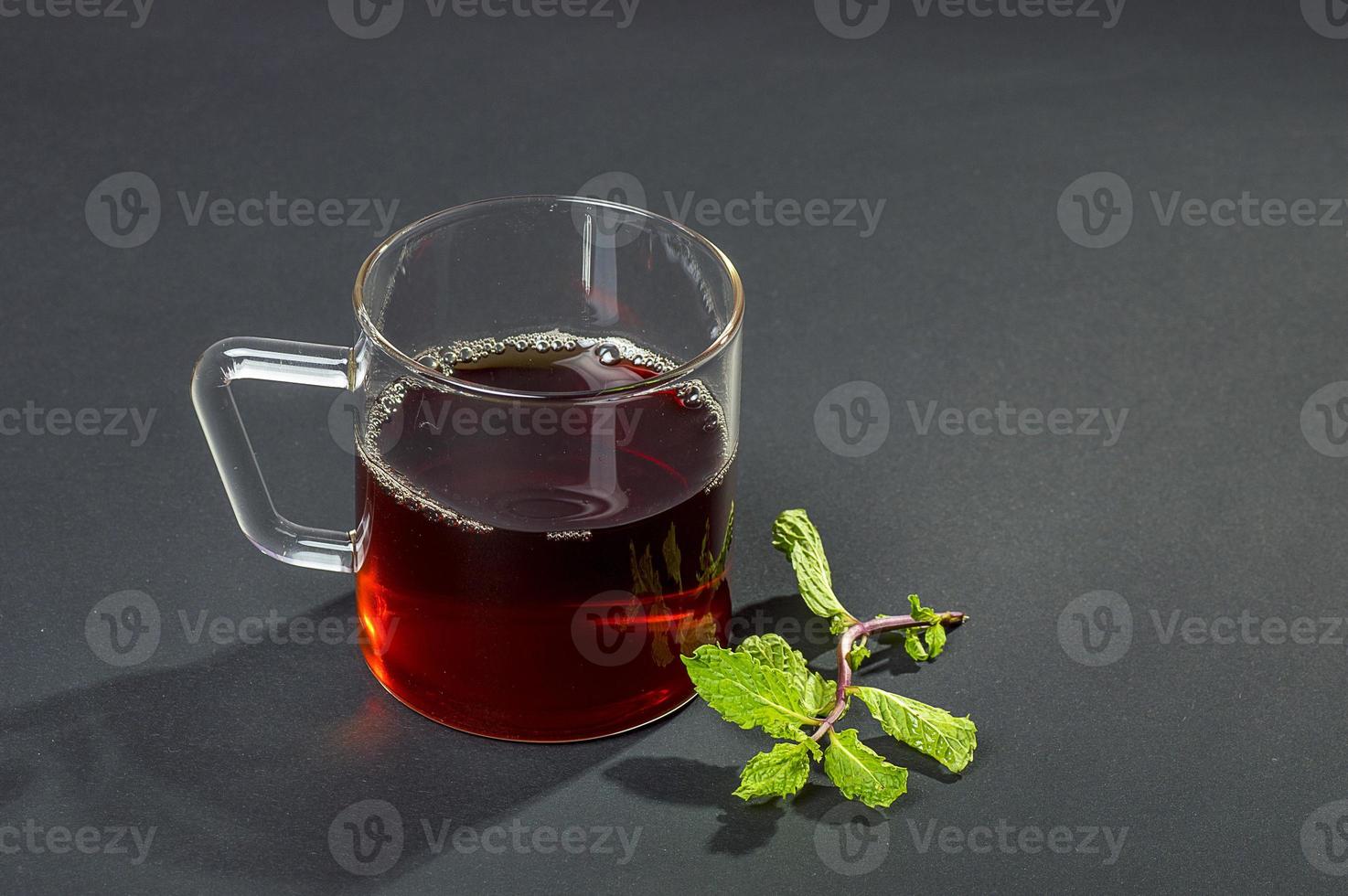 tazza di tè, menta e limone su sfondo scuro foto