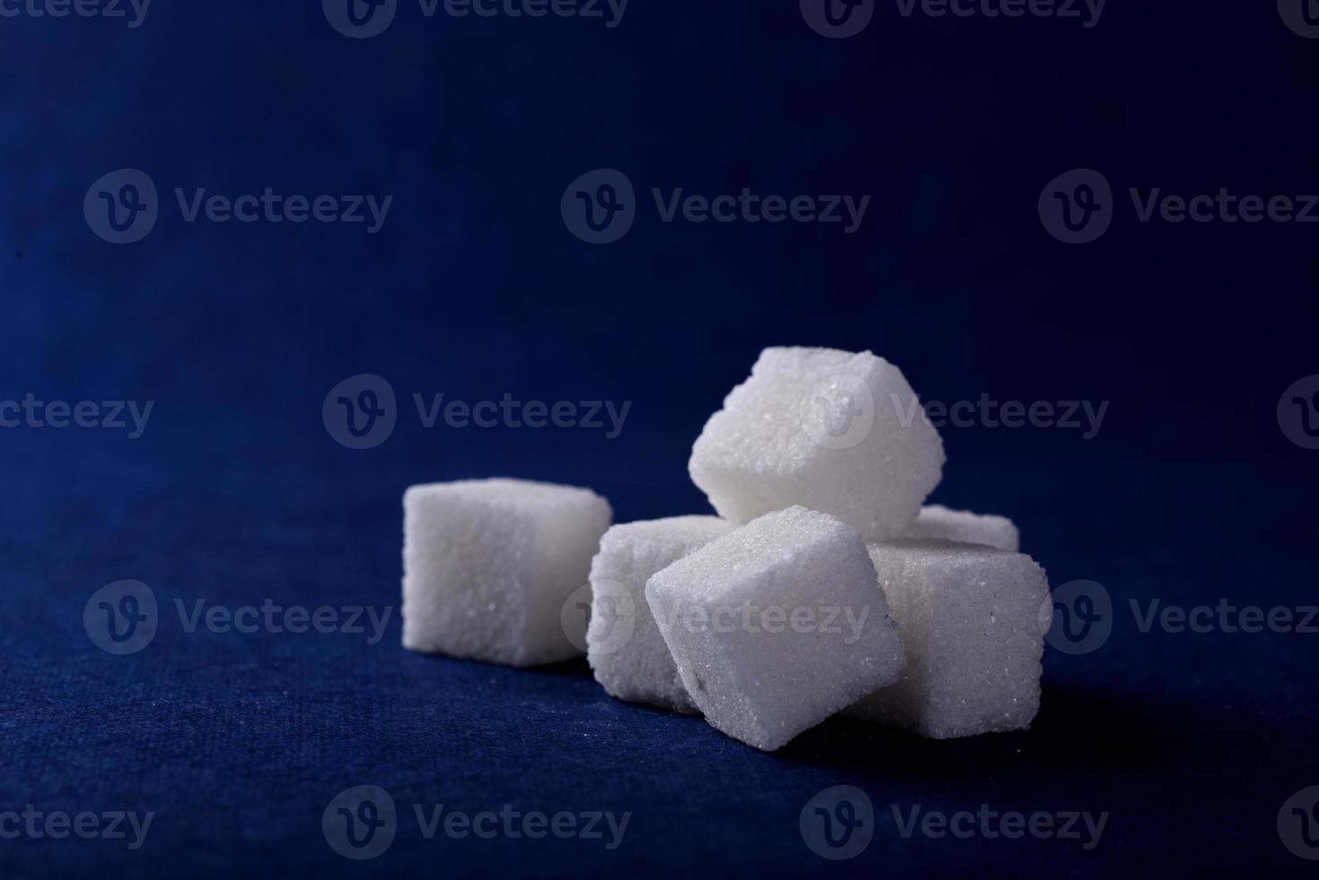 primo piano di zollette di zucchero su sfondo blu foto