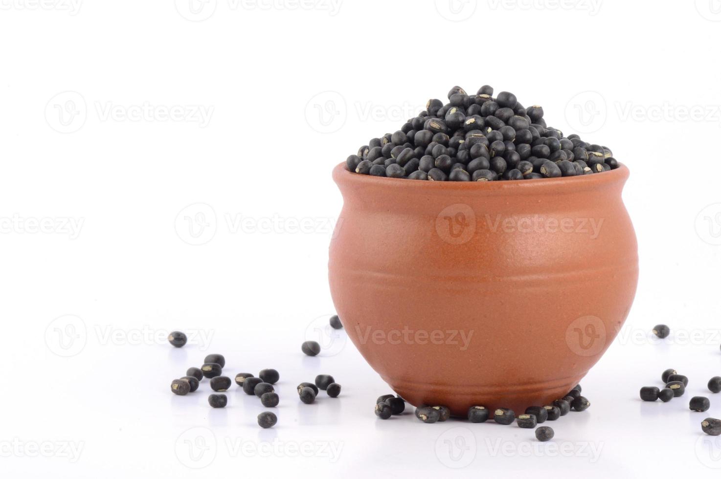 urad dal, grammo nero, vigna mungo in vaso di argilla su sfondo bianco foto