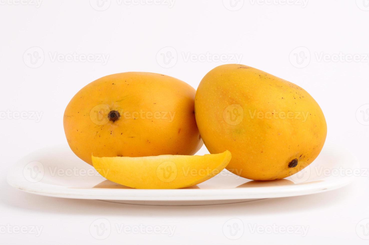 Frutto di mango in cesto con fetta su sfondo bianco foto