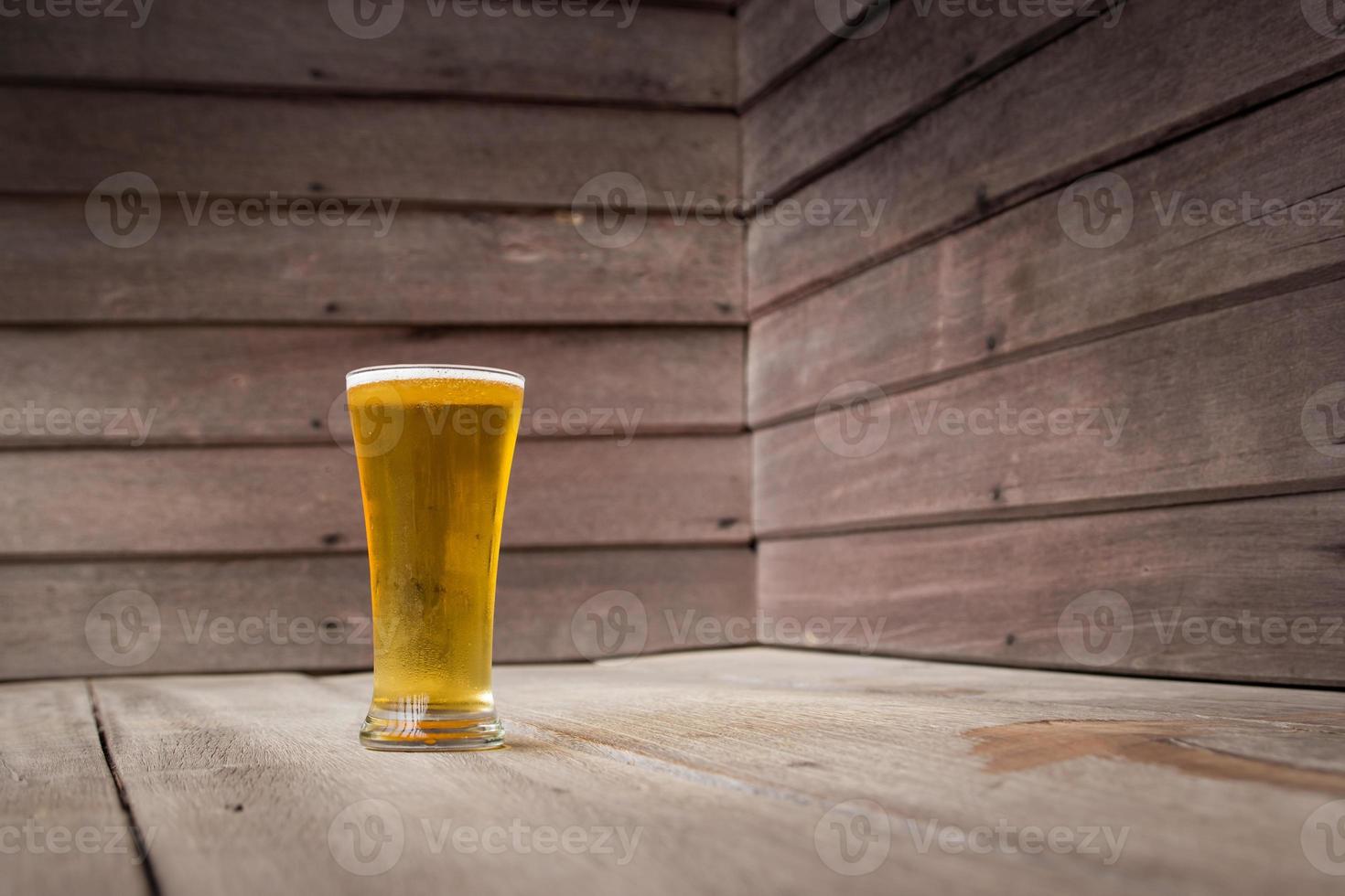 birra di vetro su fondo di legno foto