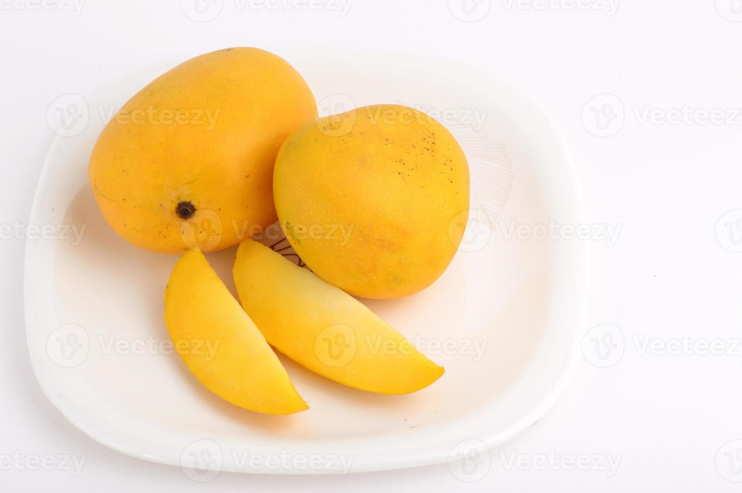 Frutto di mango in cesto con fetta su sfondo bianco foto