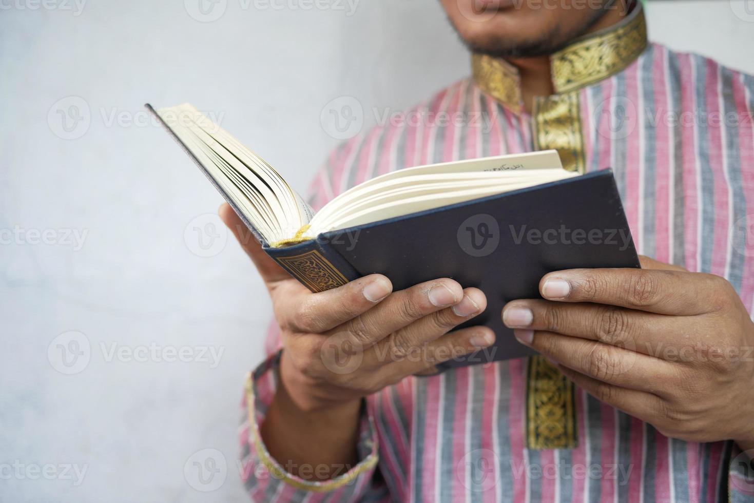 man mano musulmana leggendo il libro sacro corano con spazio di copia foto
