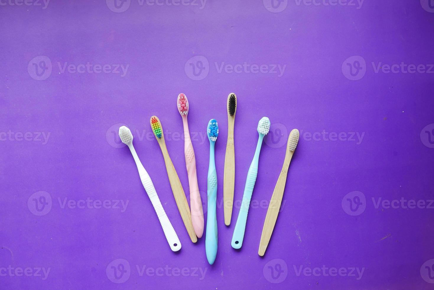 spazzolini da denti colorati su sfondo viola, vista dall'alto foto