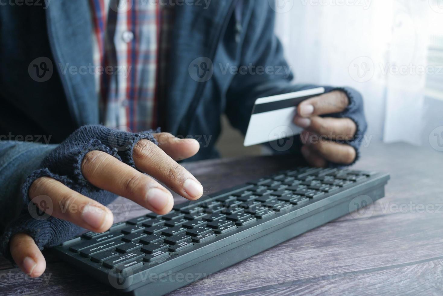 mano di hacker che ruba dati dalla carta di credito foto