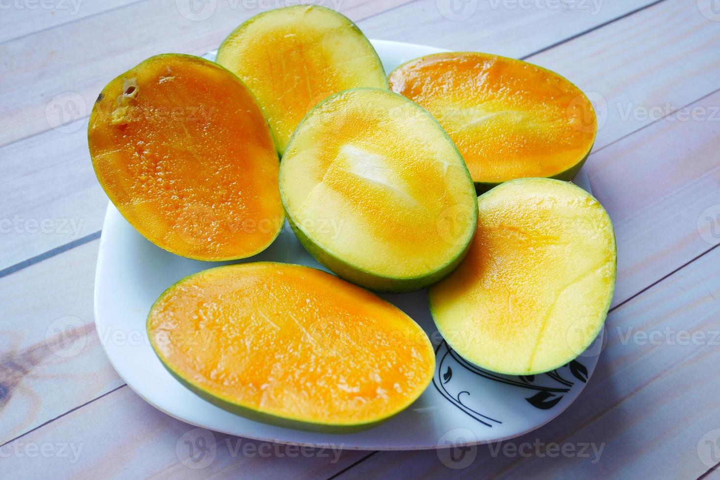 mango giallo maturo tagliato in una ciotola dall'alto verso il basso foto