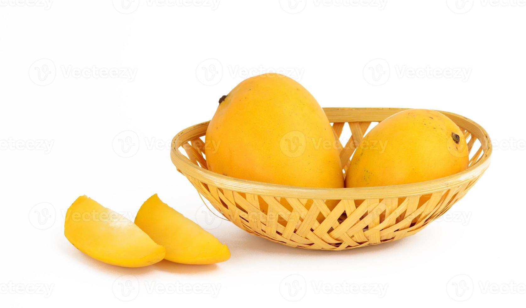 Frutto di mango in cesto con fetta su sfondo bianco foto