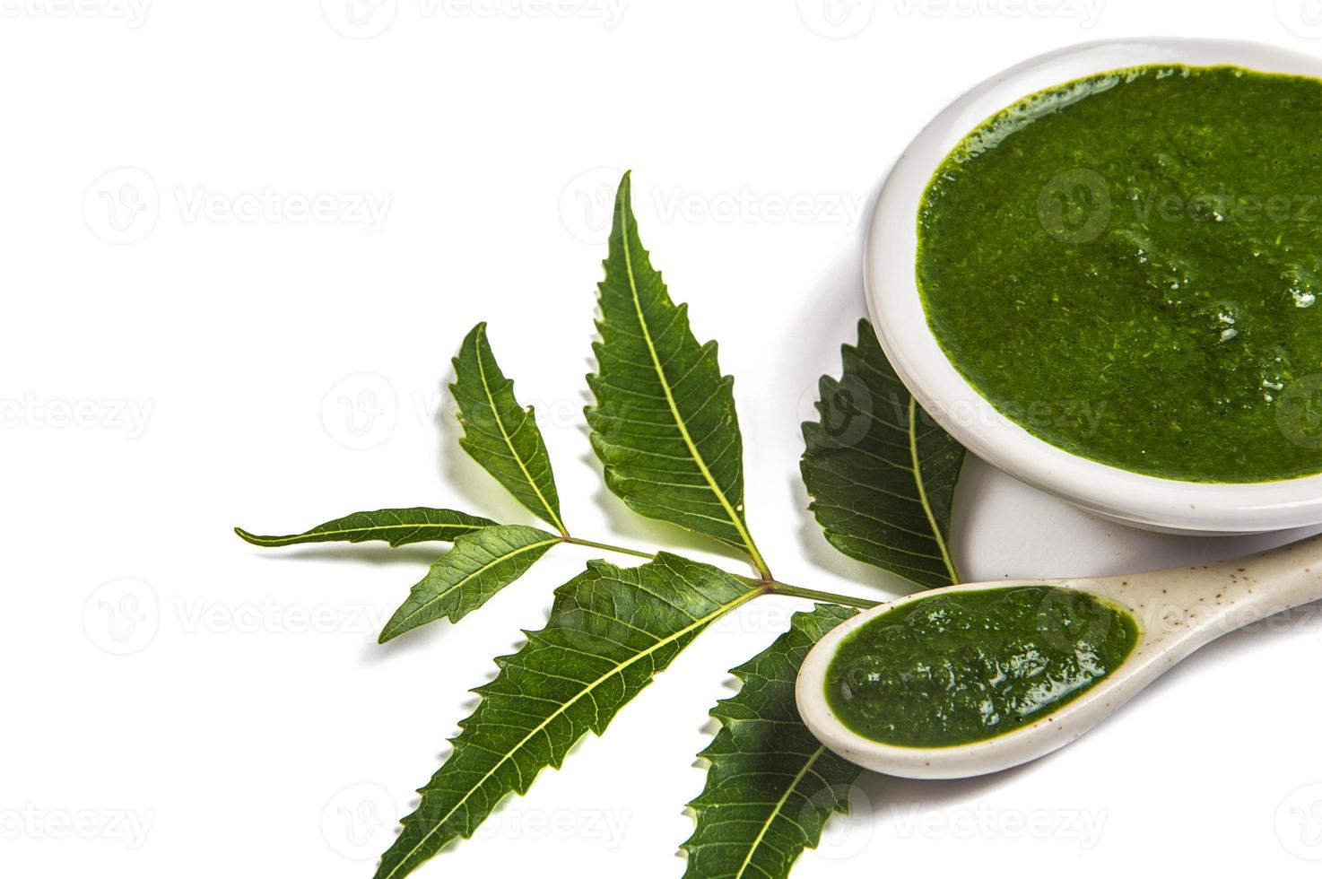 Medicinali foglie di neem con pasta di neem in cucchiaio e piastra su sfondo bianco azadirachta indica foto