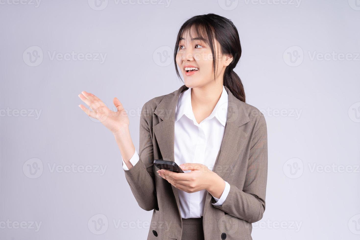 giovane imprenditrice asiatica che utilizza il telefono su sfondo bianco foto