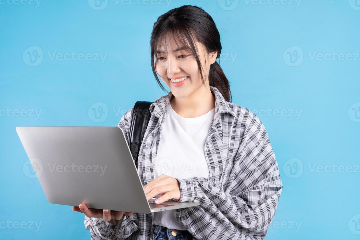 studentessa asiatica con espressione giocosa su sfondo blu foto