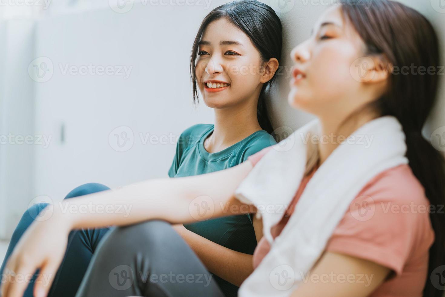 due donne asiatiche che si prendono una pausa dalla sessione di yoga foto