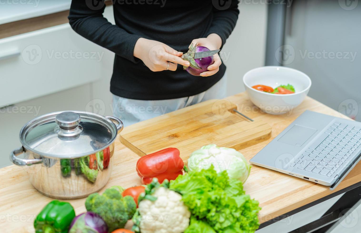 donna sta imparando a cucinare da sola a casa, corso di cucina online foto
