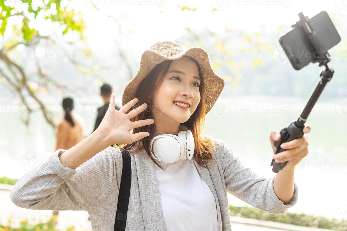 donna asiatica che registra video per strada ad hanoi, vietnam foto