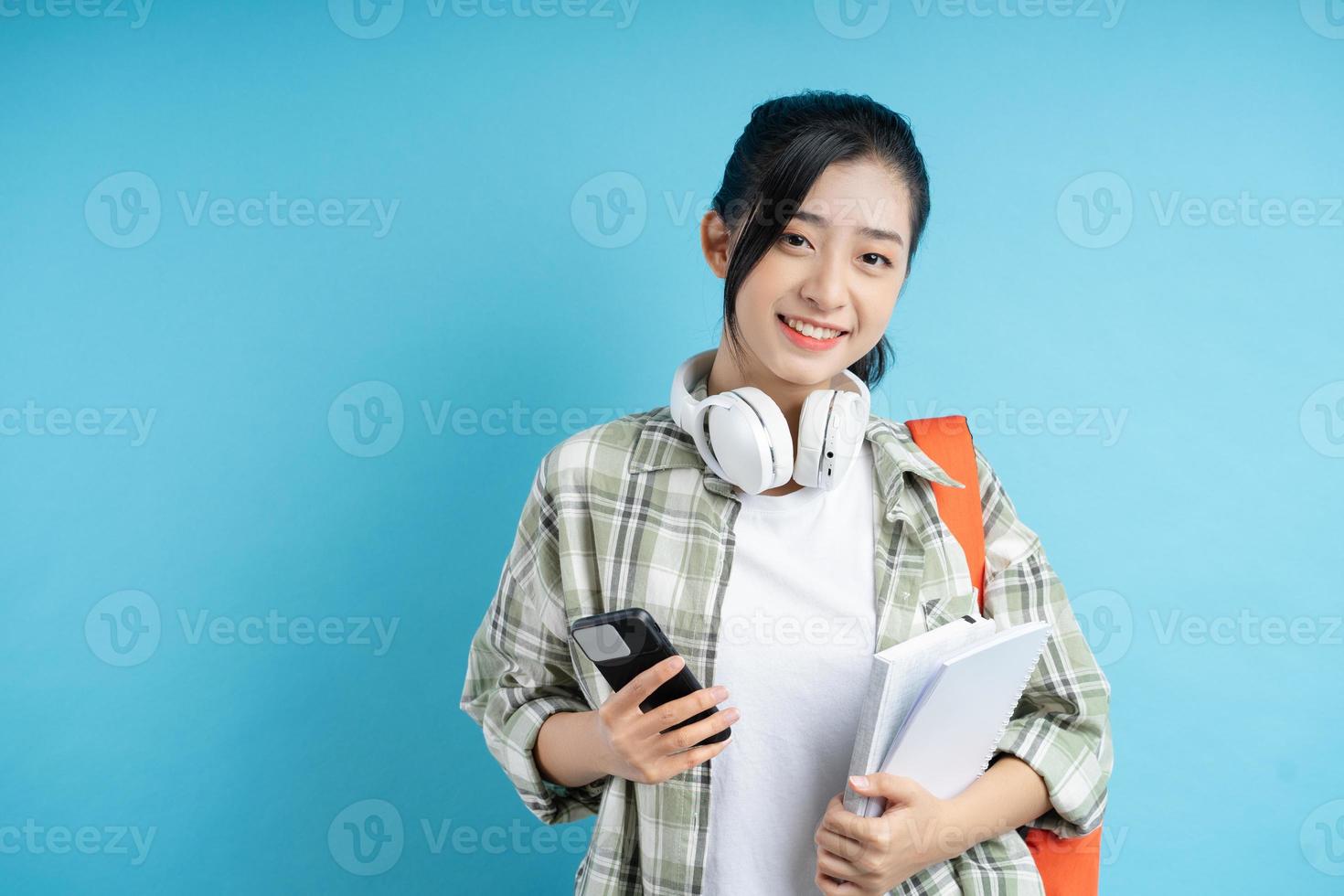 ritratto di studente asiatico su sfondo blu foto