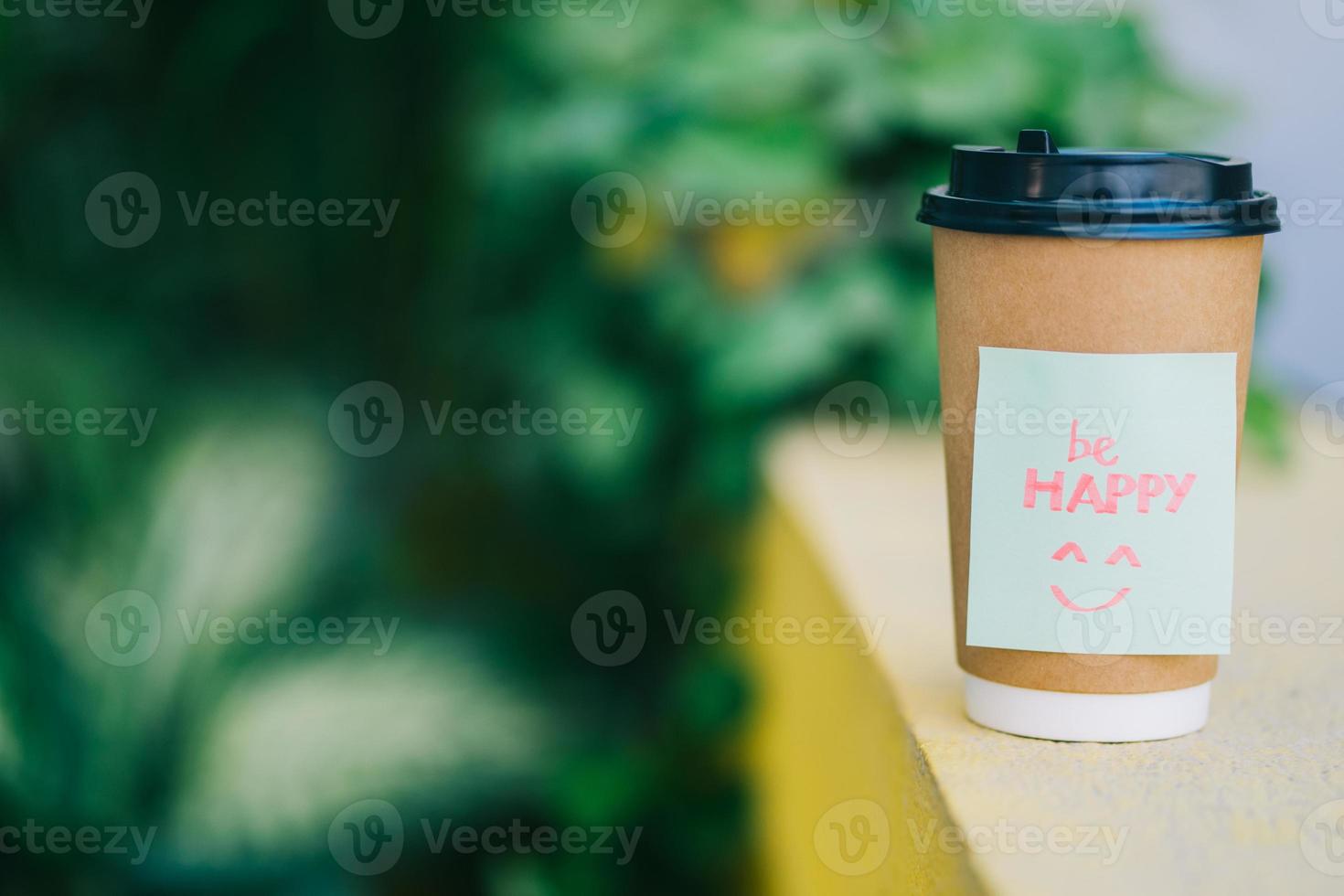 una tazza di caffè con la parola sii felice con lo sfondo della natura foto