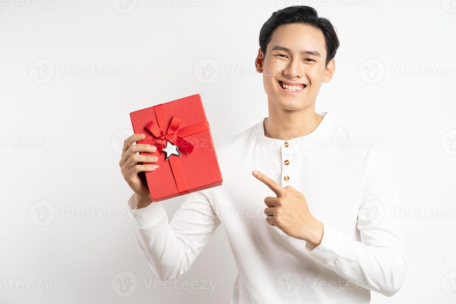 uomo d'affari asiatico tiene in mano una confezione regalo rossa su sfondo bianco white foto