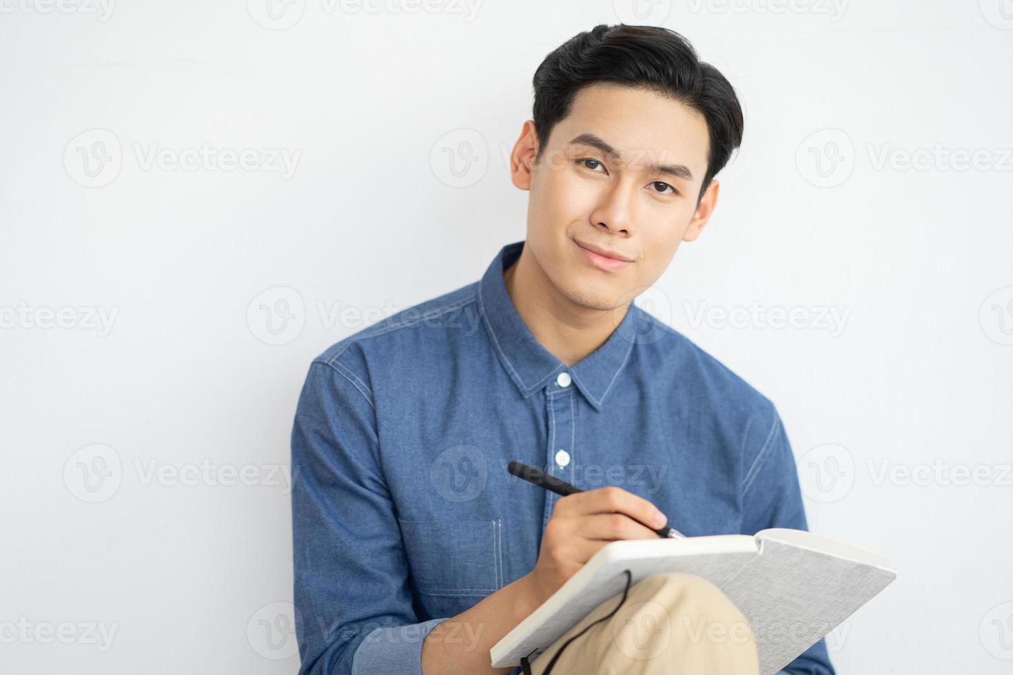 uomo asiatico seduto a casa a scrivere romanzo foto