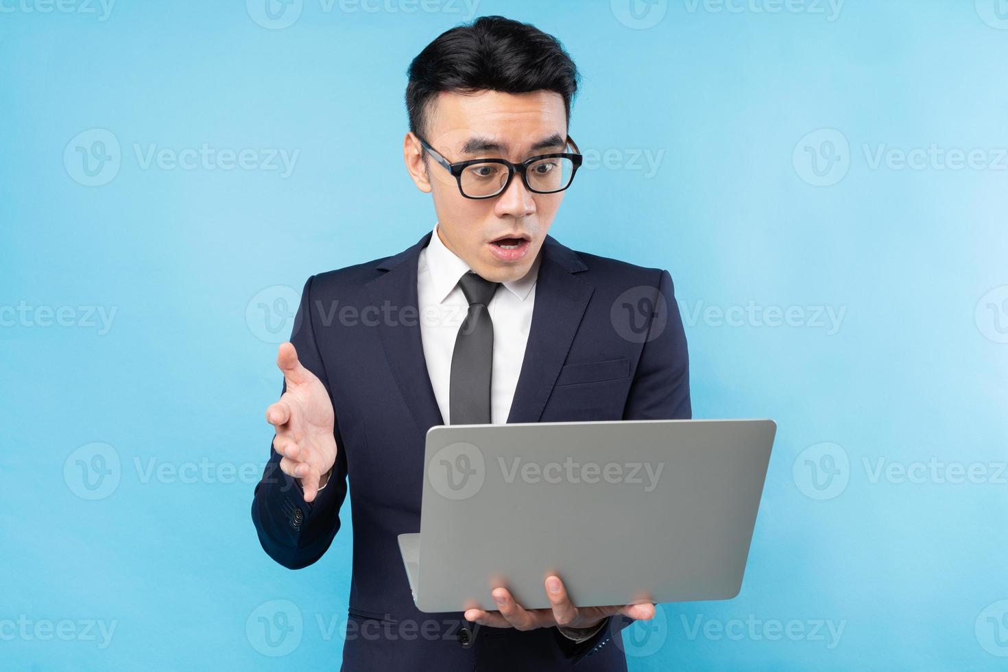uomo d'affari asiatico che indossa un abito guardando il laptop e si sente sorpreso foto