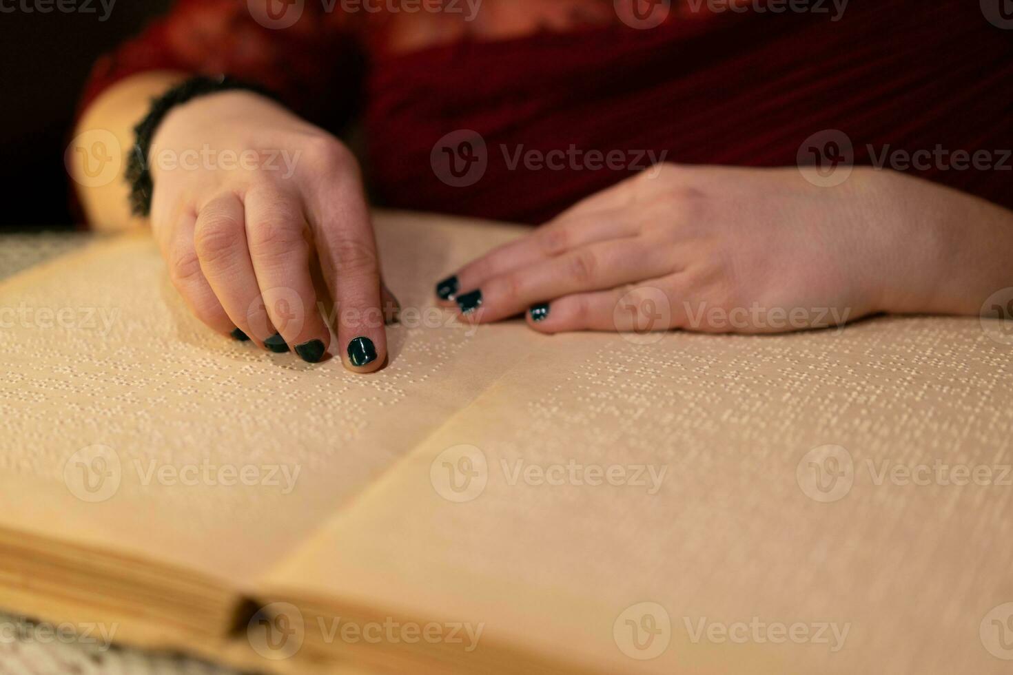 avvicinamento di un' donna di mano lettura un' braille libro foto