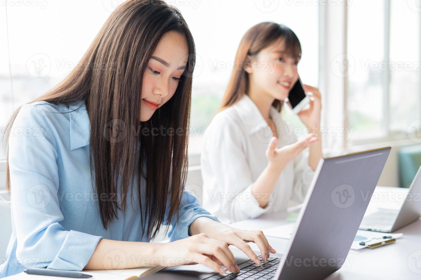 giovane donna asiatica che si concentra sul portare a termine il lavoro foto