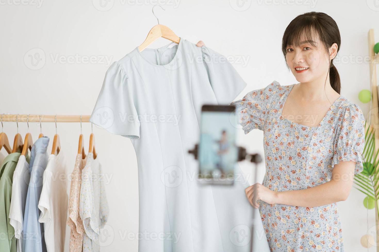 la giovane bella donna asiatica è in live streaming per vendere vestiti su piattaforme di social network e siti di e-commerce. questa sarà la tendenza futura del settore dell'e-commerce foto