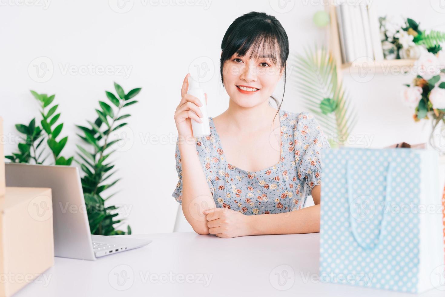 donna d'affari asiatica utilizza gli smartphone per trasmettere in streaming la vendita di cosmetici su siti di social network e siti di e-commerce. foto