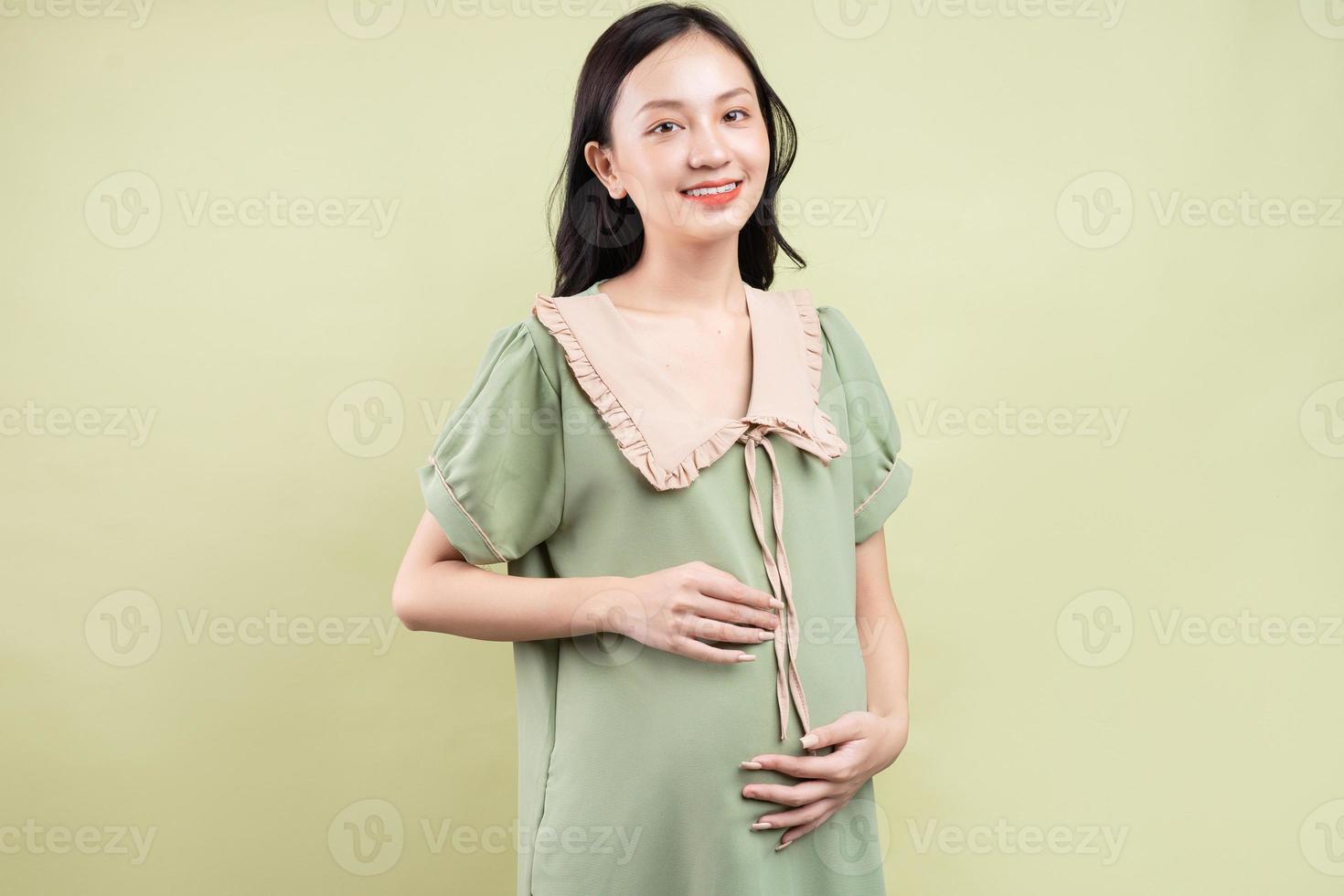 donna asiatica incinta che si sente felice e non vede l'ora di partorire foto